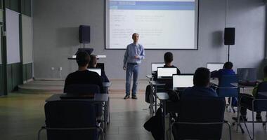 programming classes middle aged professor of computer science teaching young school students video